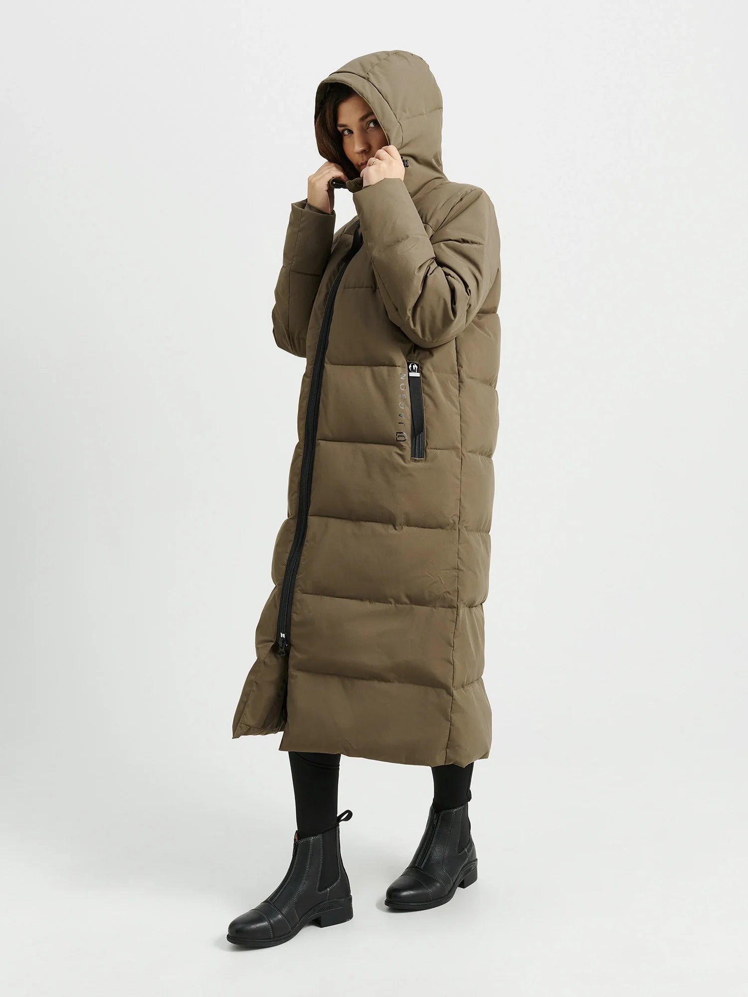 Vinterkappan Rakel, en hellång kappa med dunliknande syntetfyllning, vattenavvisande material och praktiska fickor, i färgerna svart och brungrön.